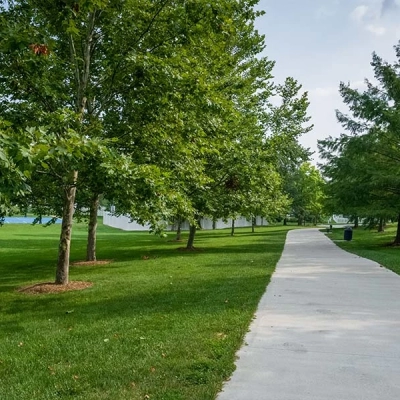 Paved walking paths circle the park underneath the shade of mature trees